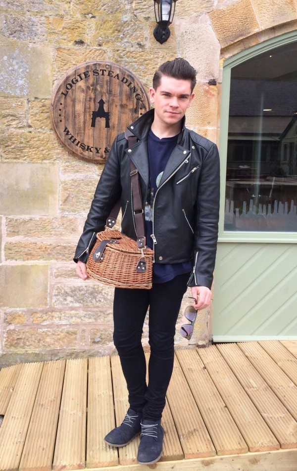 Robin James outside Logie Steading Whisky & Wine Shop with fly fishing basket